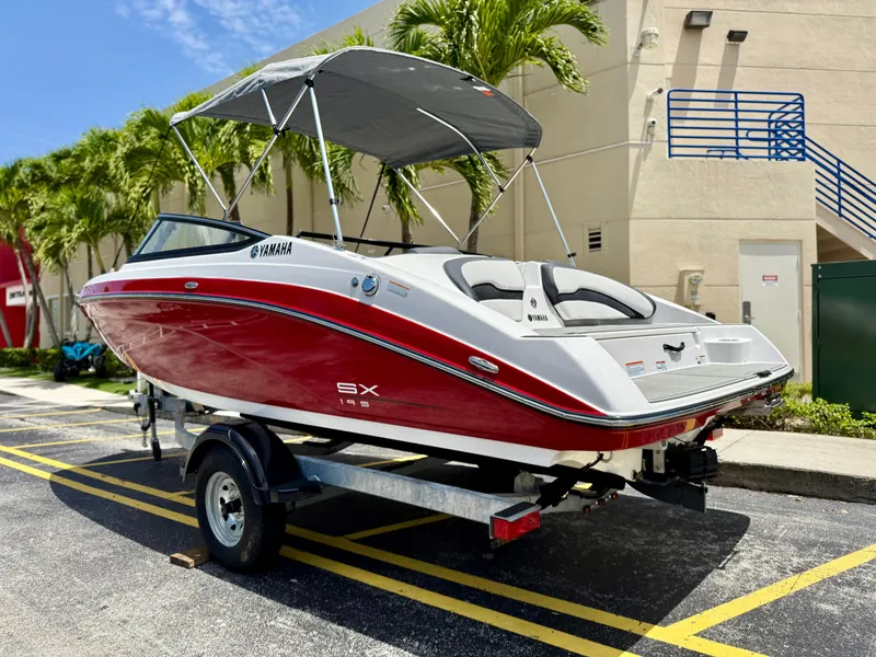 Slide: The Image of 2025 Yamaha SX195 boat with red and white design on a trailer, parked outdoors. - 4
