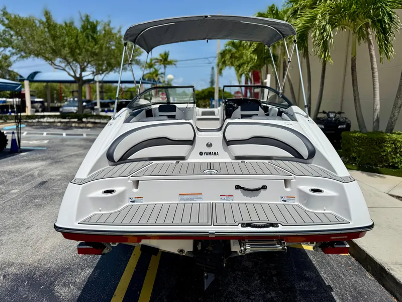 Slide: The Image of 2025 Yamaha Boats SX195, rear view, parked outdoors with canopy and seating visible. - 5