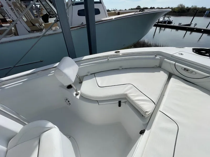 Slide: The Image of 2017 Sea Hunt Ultra 234 boat interior with white seating, docked near water. - 12