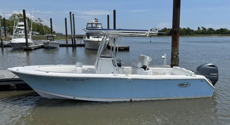Slide: The Image of 2017 Sea Hunt Ultra 234 boat docked in a marina, featuring a sleek design and Yamaha engine. - 2