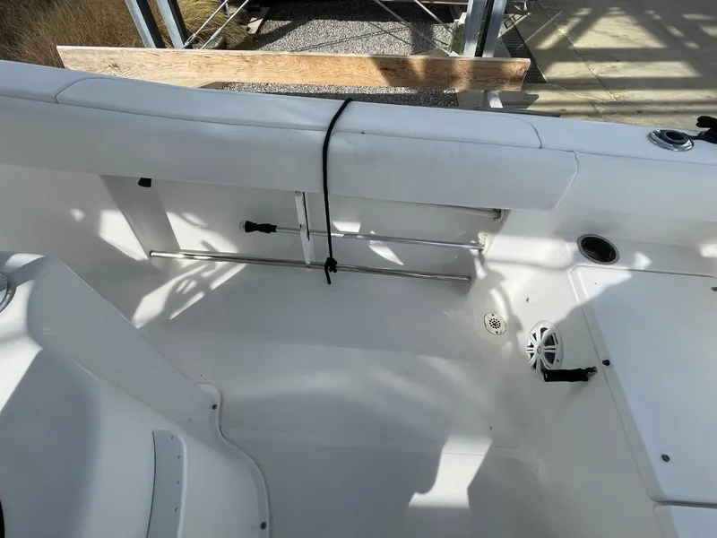 Slide: The Image of 2017 Sea Hunt Ultra 234 boat interior with white seating and storage compartments. - 21