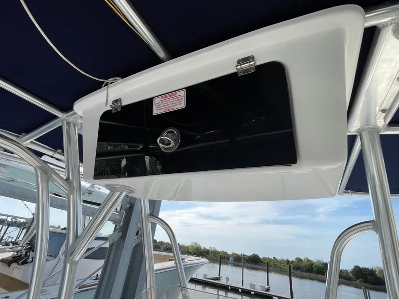 Slide: The Image of 2017 Sea Hunt Ultra 234 boat console with storage compartment, docked by the water. - 23