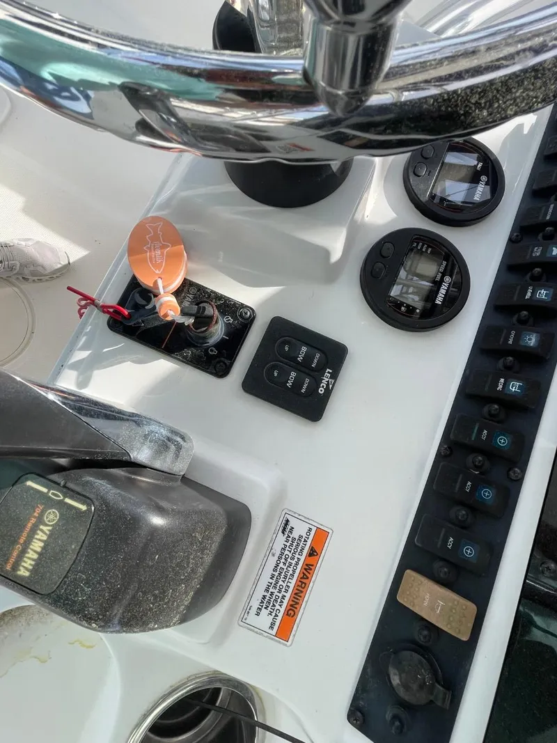 Slide: The Image of Control panel of a 2017 Sea Hunt Ultra 234 boat with steering wheel and switches. - 28