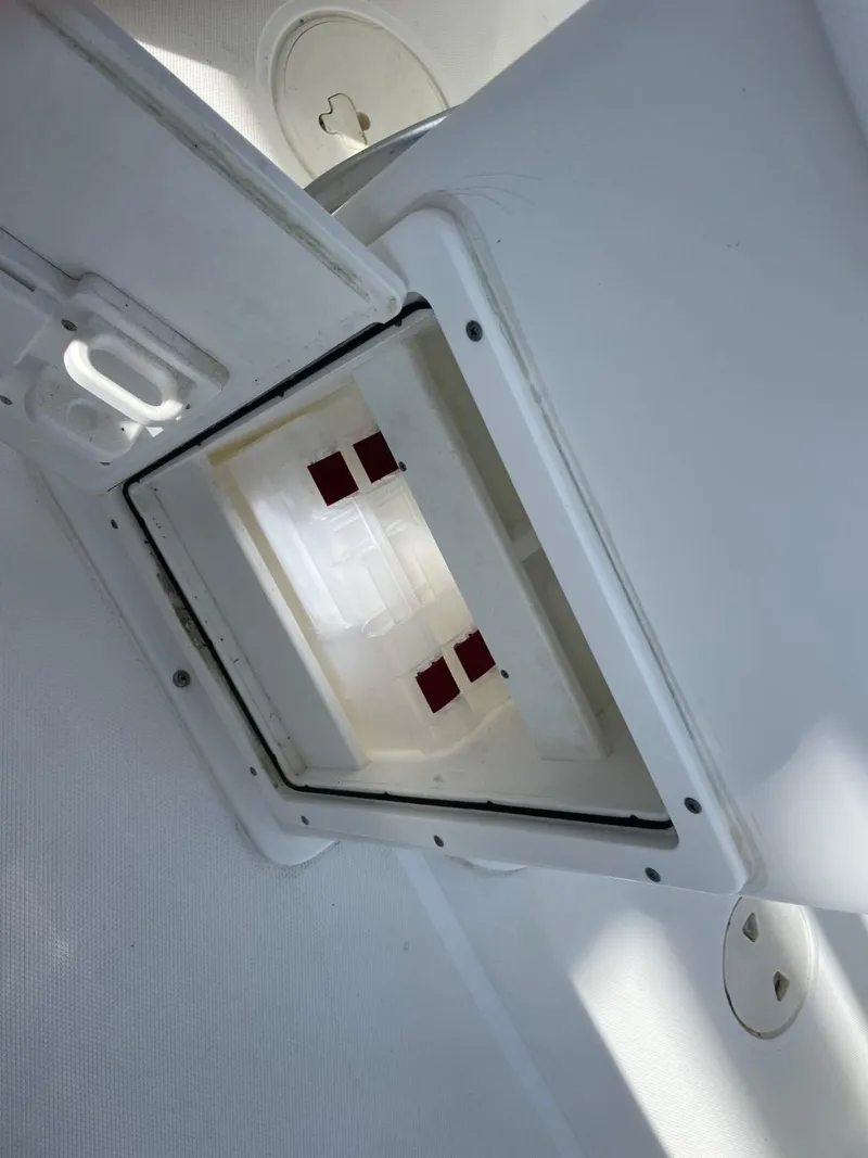 Slide: The Image of 2017 Sea Hunt Ultra 234 boat compartment interior with open hatch, showcasing storage space. - 30