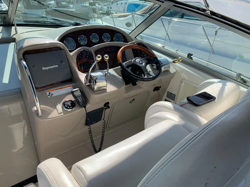 Slide: The Image of 2006 Sea Ray 340 Sundancer helm with Raymarine electronics and luxurious seating. - 17