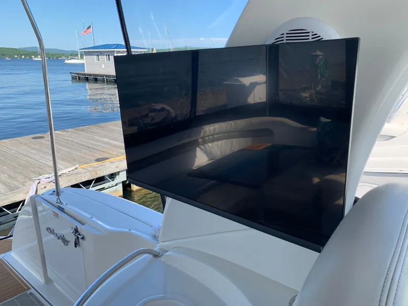 Slide: The Image of 2006 Sea Ray 340 Sundancer yacht with TV, docked by a serene lake. - 24