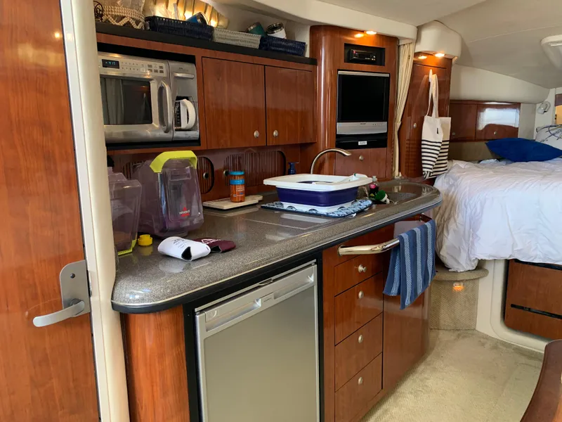 Slide: The Image of 2006 Sea Ray 340 Sundancer interior with kitchenette and cozy sleeping area. - 30
