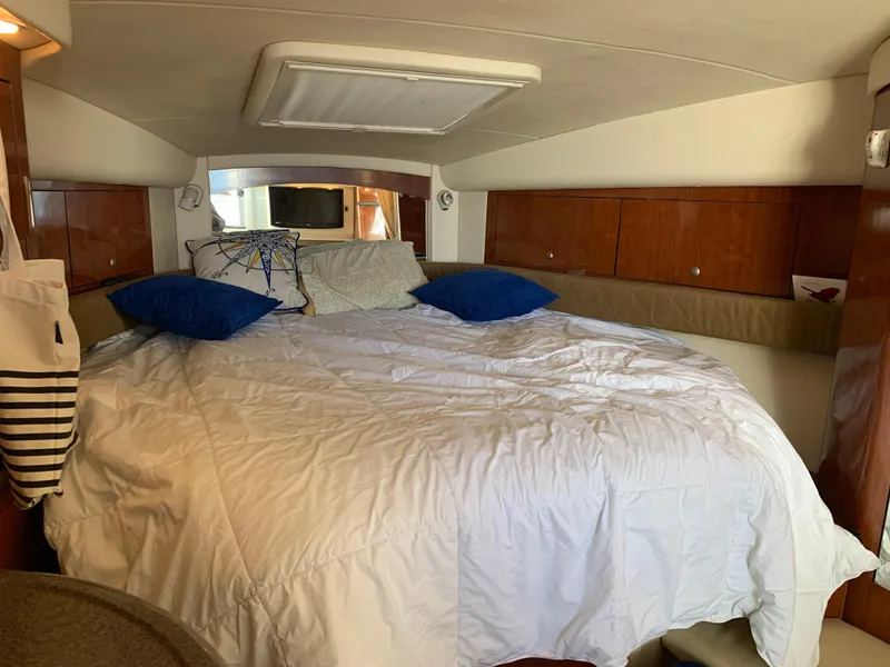 Slide: The Image of Cozy cabin interior of 2006 Sea Ray 340 Sundancer with bed and wooden cabinets. - 31