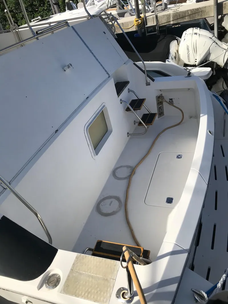 Slide: The Image of 1994 Hatteras 42 Cockpit Motor Yacht, white deck, docked with visible outboard motor. - 14