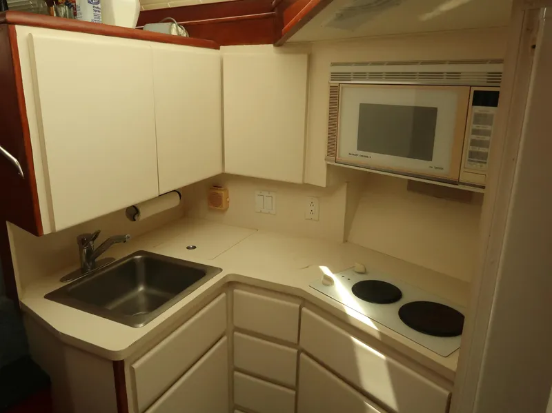 Slide: The Image of Compact kitchen in 1994 Hatteras 42 Cockpit Motor Yacht with sink, stove, and microwave. - 26