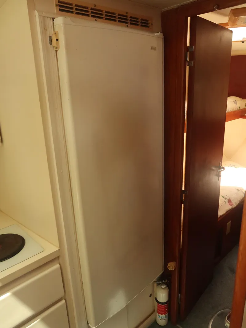 Slide: The Image of Interior of 1994 Hatteras 42 Cockpit Motor Yacht with fridge and cabin door. - 33