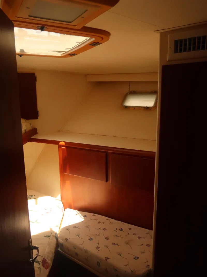 Slide: The Image of Cozy cabin interior of 1994 Hatteras 42 Cockpit Motor Yacht with twin beds and wooden accents. - 34