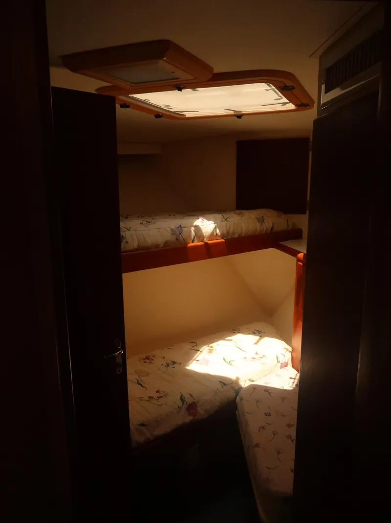 Slide: The Image of Interior of 1994 Hatteras 42 Cockpit Motor Yacht with bunk beds and natural light. - 36
