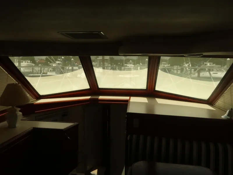 Slide: The Image of Interior view of 1994 Hatteras 42 Cockpit Motor Yacht with large windows and cozy seating. - 39