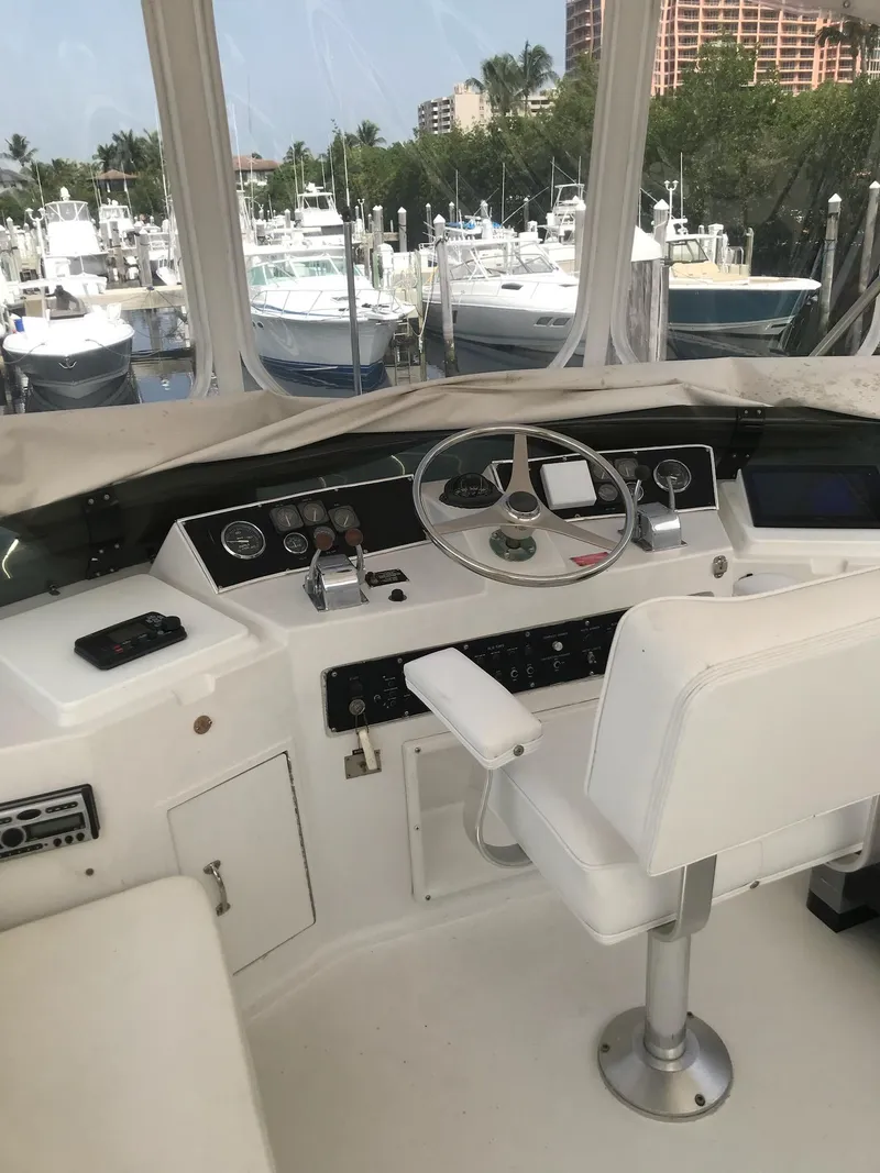 Slide: The Image of Cockpit of 1994 Hatteras 42 Cockpit Motor Yacht with marina view. - 9