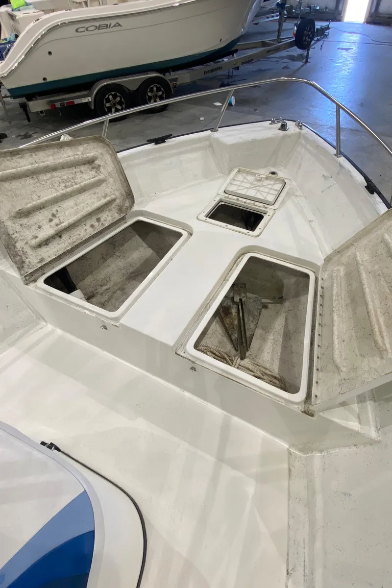 Slide: The Image of 2000 Triton 18 Sea Flight boat with open storage compartments in a garage setting. - 10