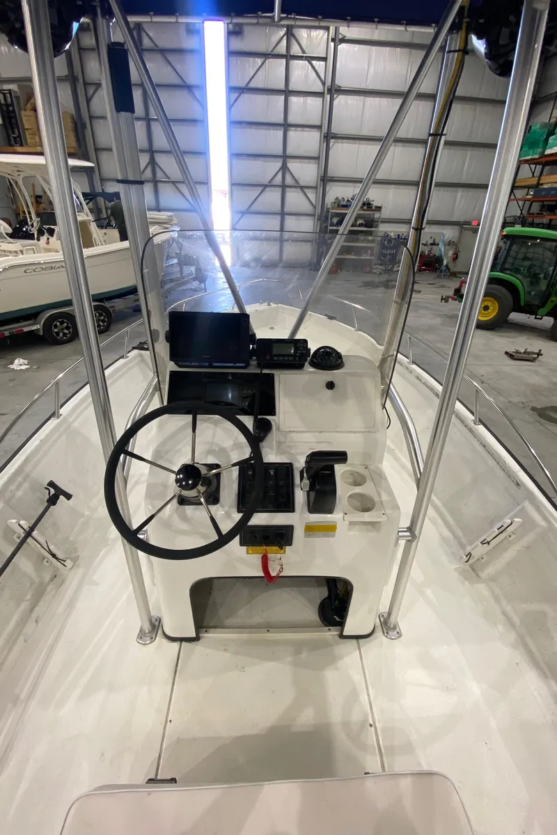 Slide: The Image of Triton 18 Sea Flight 2000 boat interior with steering wheel and control panel in a warehouse. - 13