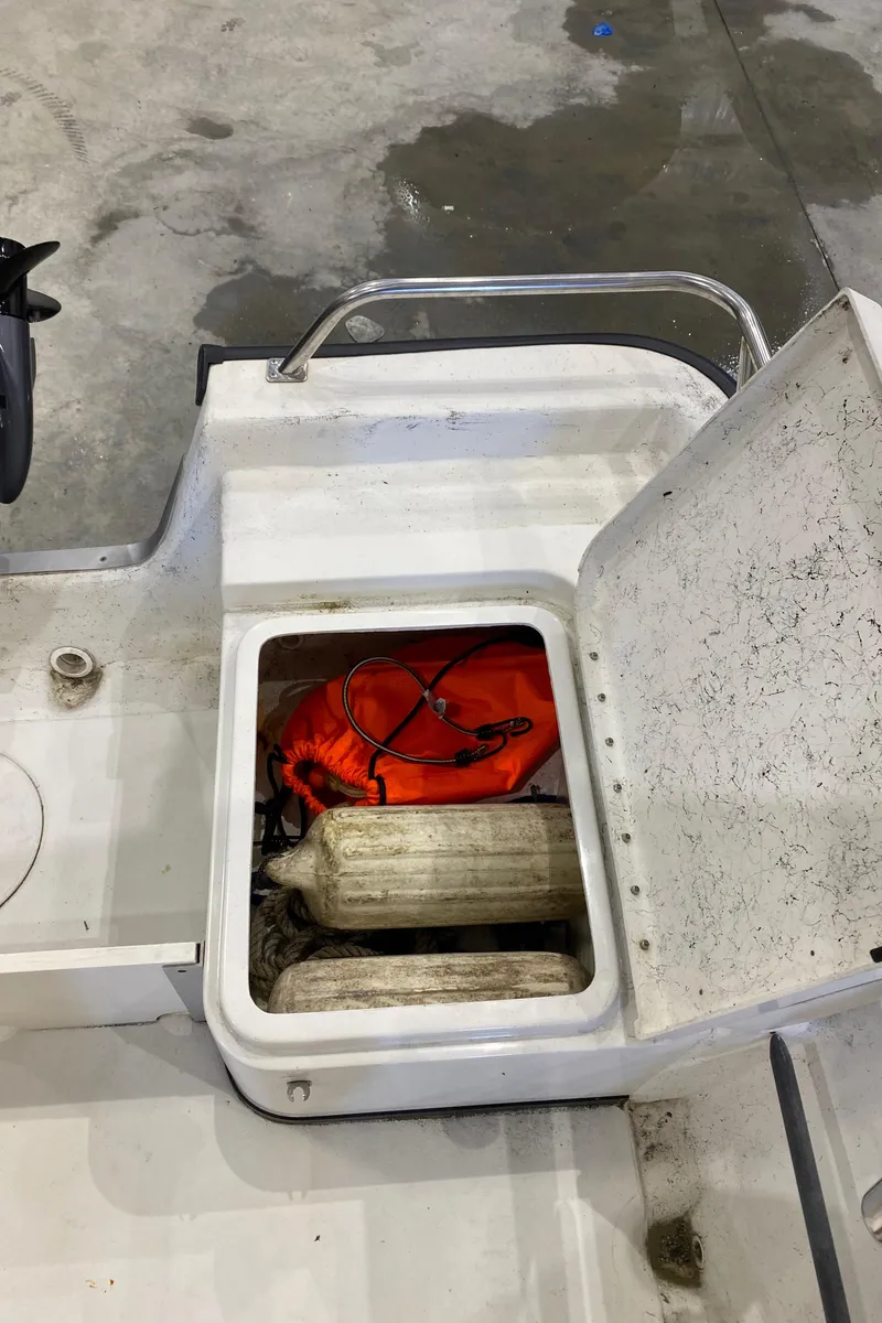 Slide: The Image of Open storage compartment on 2000 Triton 18 Sea Flight boat with marine equipment. - 15