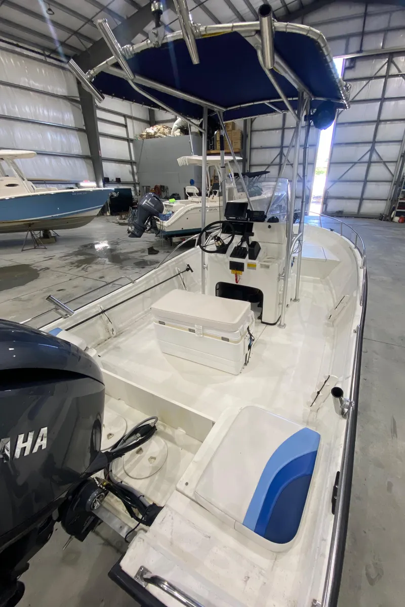 Slide: The Image of 2000 Triton 18 Sea Flight boat in storage, featuring Yamaha engine and blue canopy. - 7
