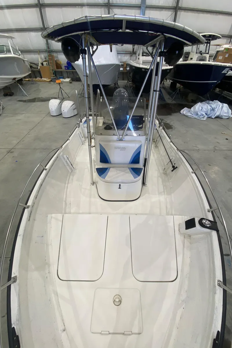 Slide: The Image of 2000 Triton 18 Sea Flight boat in storage, featuring a center console and T-top. - 9