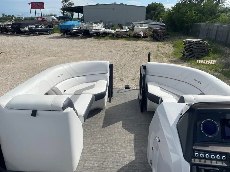 Slide: The Image of 2022 Misty Harbor Diamante Series boat with white seating and control panel, parked outdoors. - 14