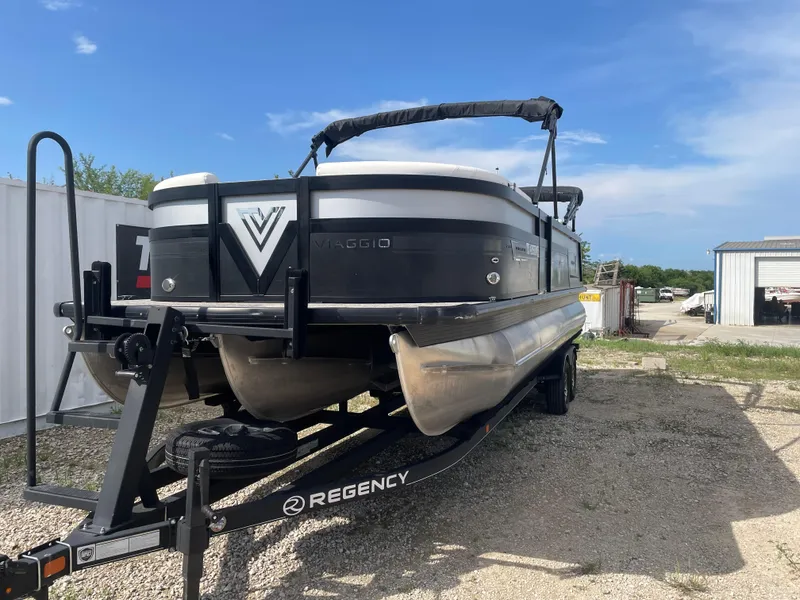 Slide: The Image of 2022 Misty Harbor Diamante Series pontoon boat on trailer under clear blue sky. - 6