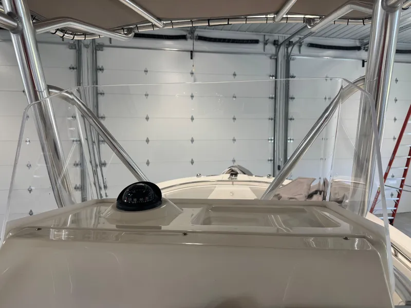 Slide: The Image of 2011 Edgewater 228CC boat console with compass, in a garage setting. - 13