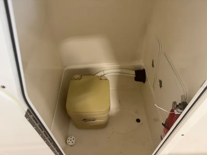 Slide: The Image of Interior of 2011 Edgewater 228CC boat with portable toilet and fire extinguisher. - 14