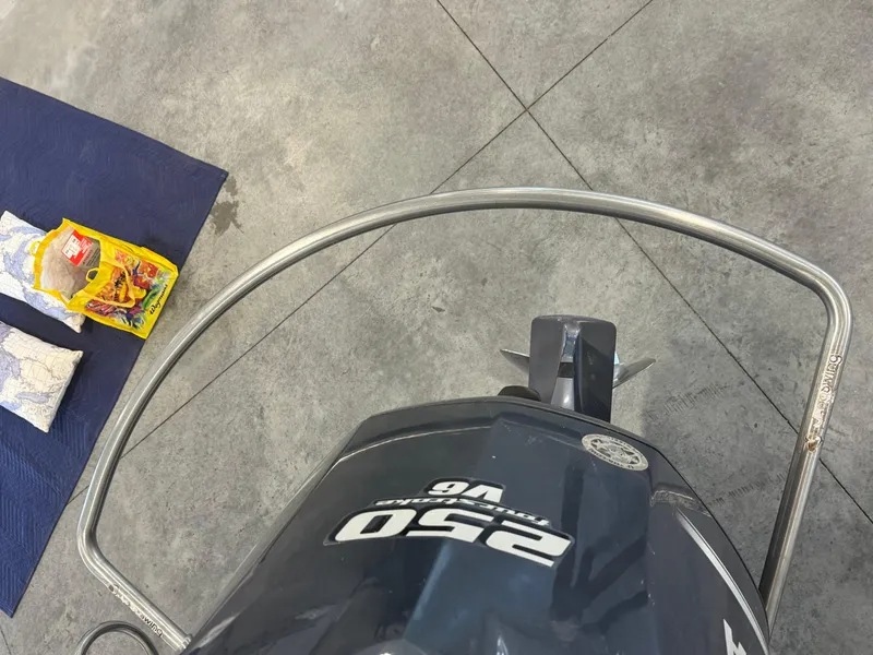 Slide: The Image of Outboard motor on Edgewater 228CC boat, 2011 model, with maps and supplies nearby. - 16