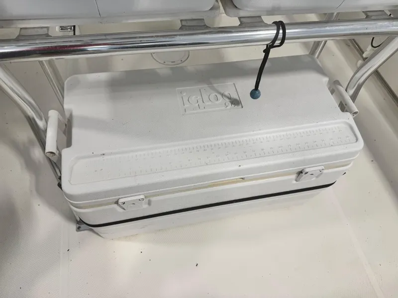 Slide: The Image of White Igloo cooler on a 2011 Edgewater 228CC boat, secured with a bungee cord. - 19