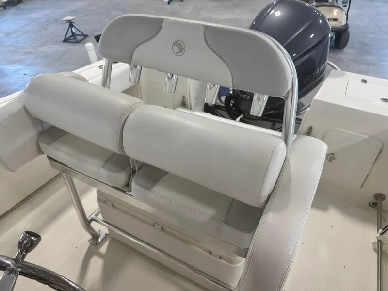 Slide: The Image of 2011 Edgewater 228CC boat interior with white seating and Yamaha outboard motor. - 20