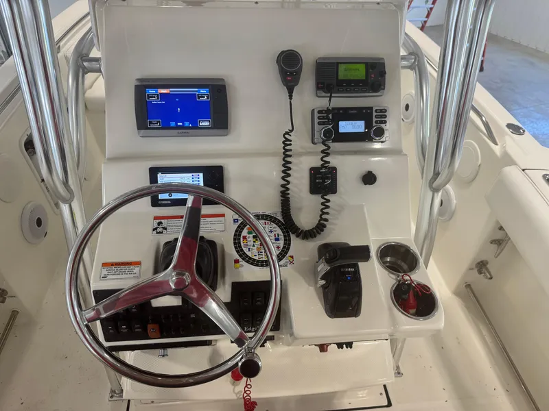 Slide: The Image of 2011 Edgewater 228CC boat console with steering wheel, navigation, and communication equipment. - 21