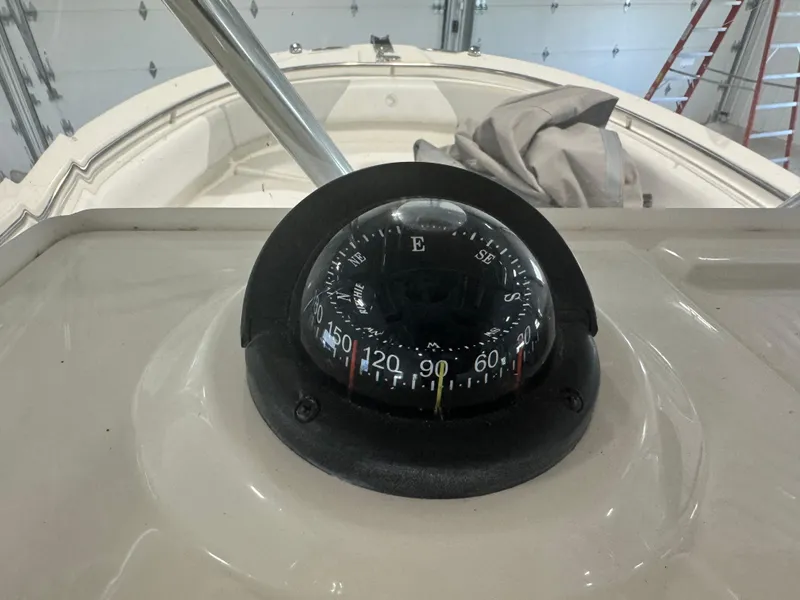 Slide: The Image of Compass on 2011 Edgewater 228CC boat dashboard in a garage setting. - 27