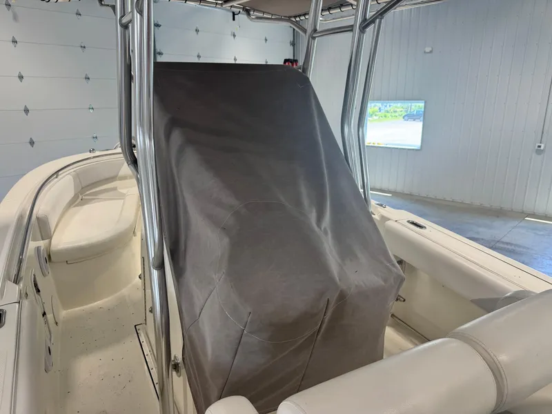 Slide: The Image of 2011 Edgewater 228CC boat interior with covered console in a garage setting. - 7