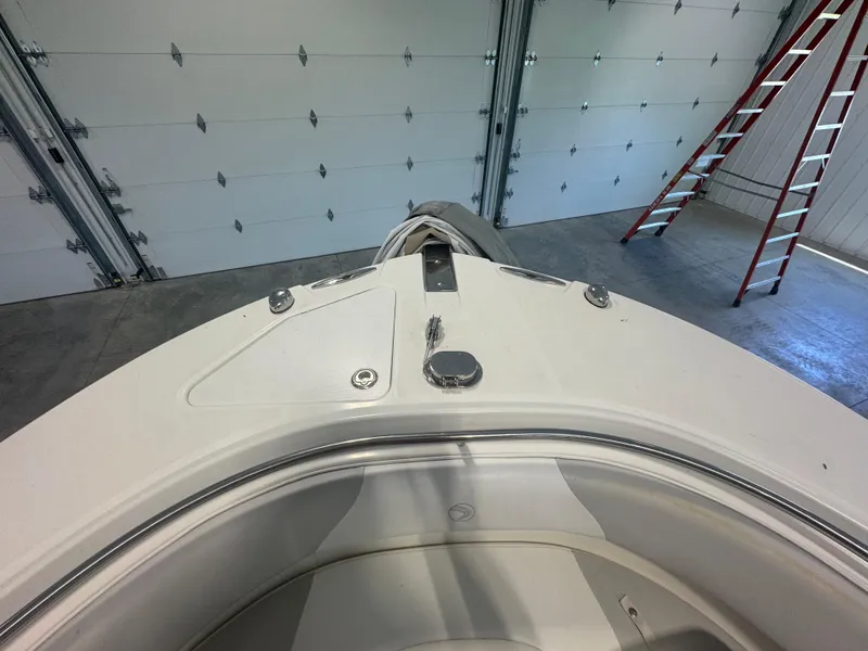 Slide: The Image of 2011 Edgewater 228CC boat bow in garage with ladder and closed doors. - 9