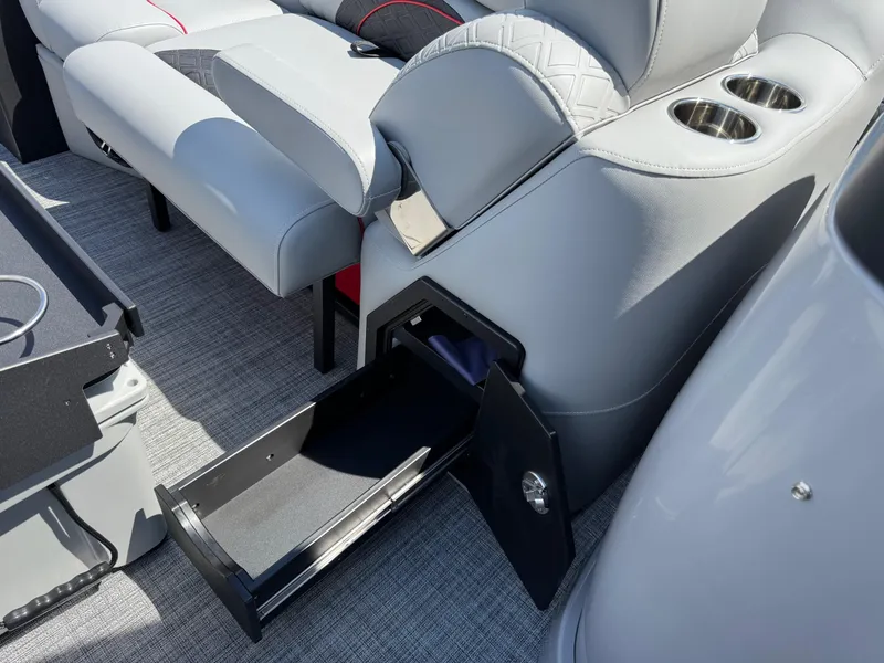 Slide: The Image of 2026 JC SportToon 24 TT DSL boat interior with open storage drawer and cup holders. - 11