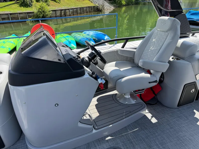 Slide: The Image of 2026 JC SportToon 24 TT DSL boat interior with captain's chair and control console. - 13