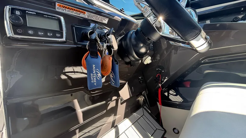 Slide: The Image of Dashboard of a 2014 Monterey 328 Super Sport boat with steering wheel and controls. - 14