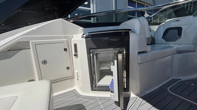 Slide: The Image of 2014 Monterey 328 Super Sport boat interior with open mini fridge and seating area. - 21