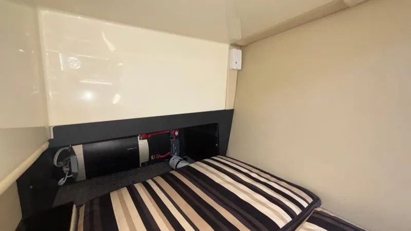 Slide: The Image of Interior cabin of 2014 Monterey 328 Super Sport with striped bedding and storage area. - 27