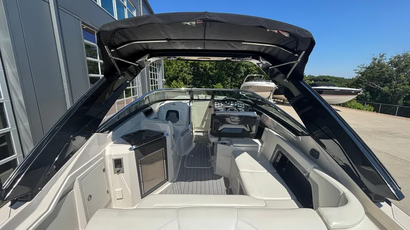 Slide: The Image of 2014 Monterey 328 Super Sport boat interior with seating and canopy, docked outdoors. - 36