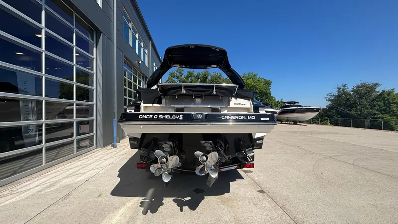 Slide: The Image of 2014 Monterey 328 Super Sport boat at a marina, rear view with dual propellers. - 6