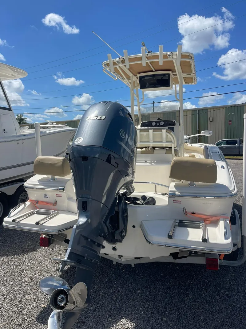 Slide: The Image of 2019 Pioneer 202 Sportfish boat with Yamaha outboard motor, parked outdoors under blue sky. - 6