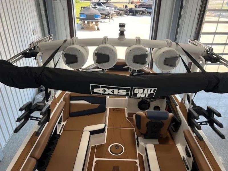 Slide: The Image of 2024 Axis T250 boat interior with speakers and seating, viewed from above in a garage. - 12