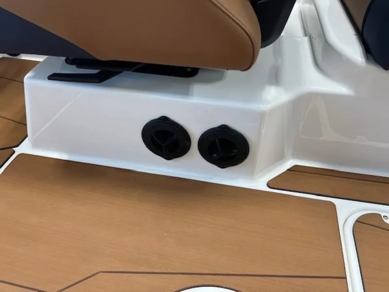 Slide: The Image of 2024 Axis T250 boat interior with brown seating and dual cup holders. - 16