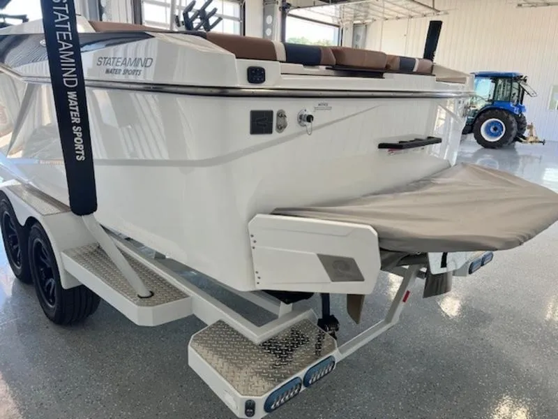 Slide: The Image of 2024 Axis T250 boat on trailer in showroom with tractor in background. - 8