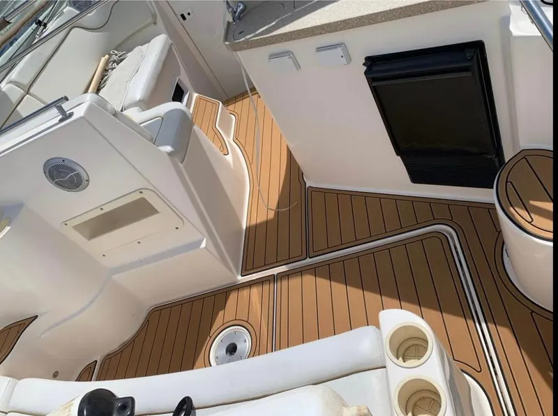 Slide: The Image of 2006 Rinker 300 Fiesta Vee boat interior with wood flooring and seating area. - 6