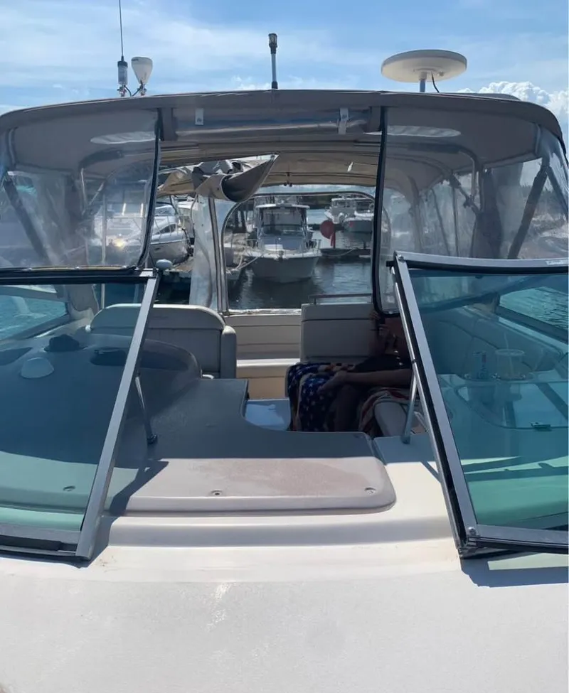 Slide: The Image of 2006 Rinker 300 Fiesta Vee boat docked at marina, featuring open cockpit and clear canopy. - 8