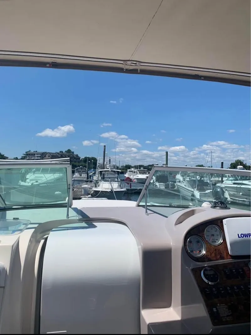 Slide: The Image of 2006 Rinker 300 Fiesta Vee boat dashboard with marina view under clear blue sky. - 9