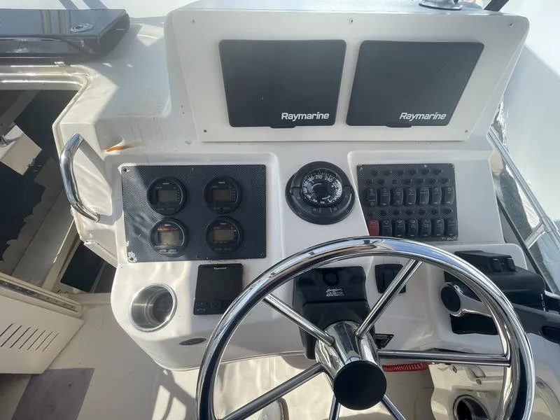 Slide: The Image of 2003 Grady-White Sailfish 282 helm with Raymarine electronics and steering wheel. - 11